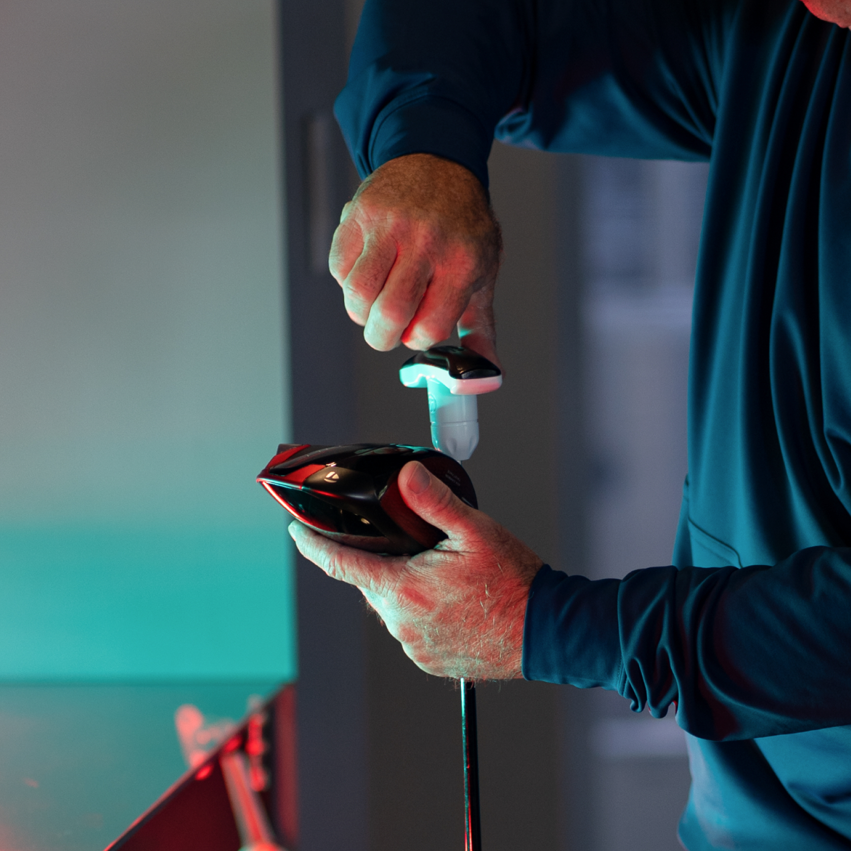 Close-up of a club fitter adjusting a driver head during a custom fitting session at Studio Golf El Paso.