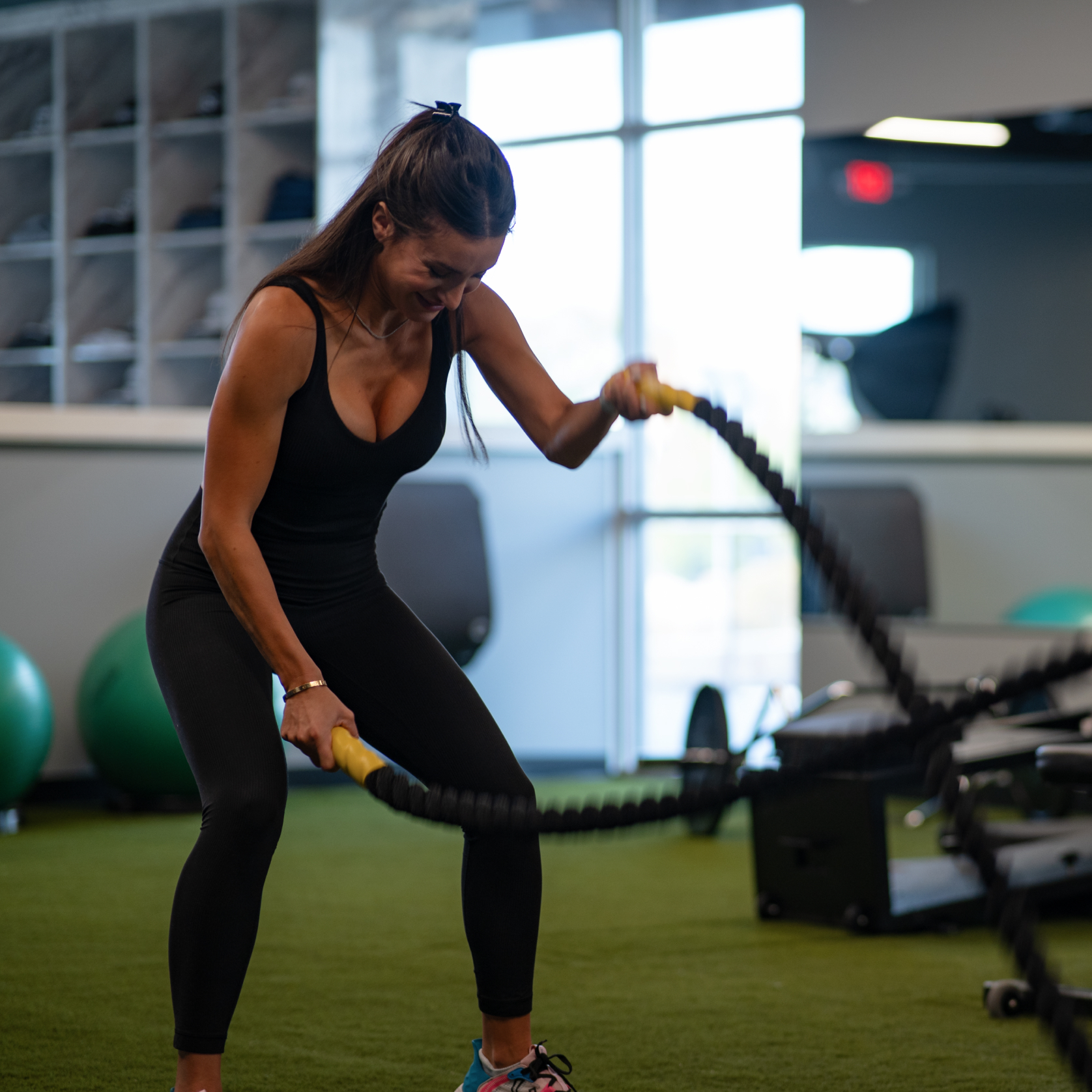 Trainer leading a fitness session with battle ropes at Studio Golf El Paso to build strength and mobility for golfers.