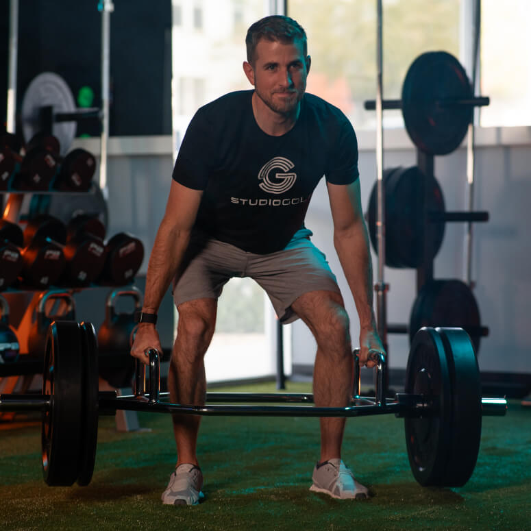 Athlete performing a deadlift exercise during a golf fitness session at Studio Golf San Diego.